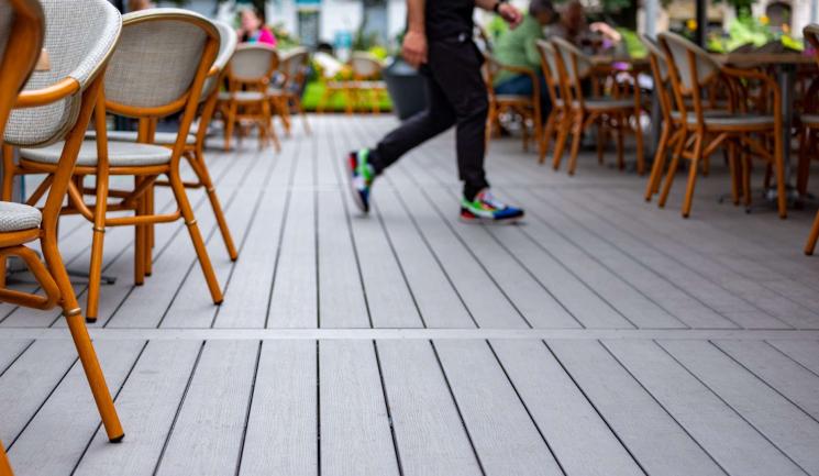Serveur en mouvement sur la terrasse d'un restaurant de couleur gris anthracite